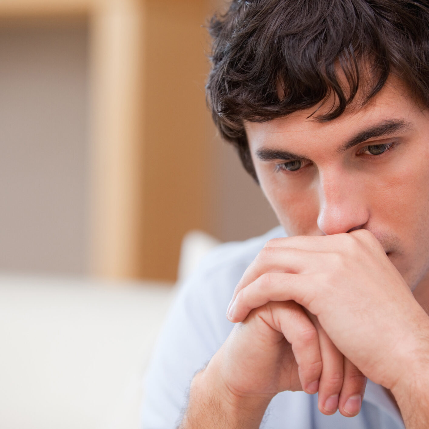 man with chin on hands with sorrowful expression