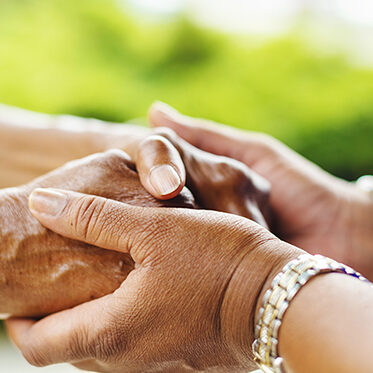 two women hold hands with ocus only on hands